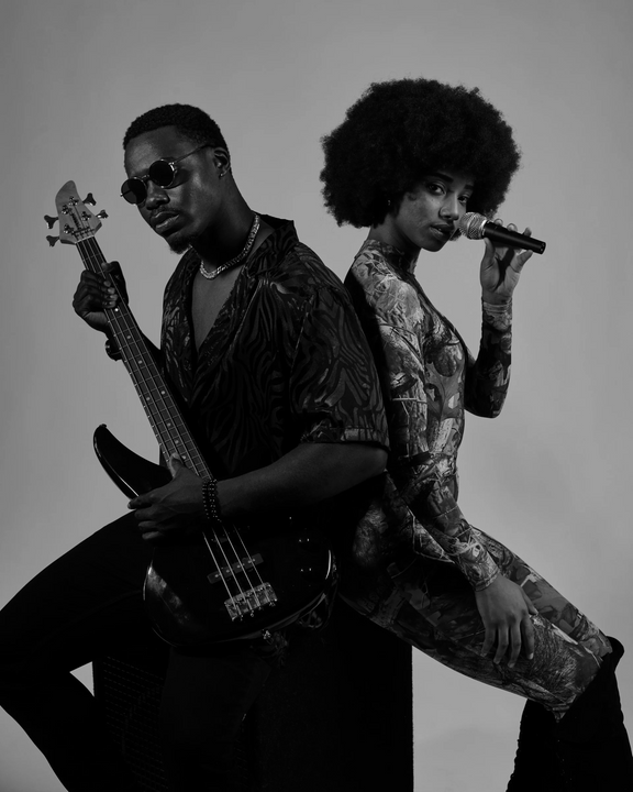a black and white photo of a man and woman with guitars