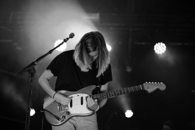 a black and white photo of a person playing an electric guitar